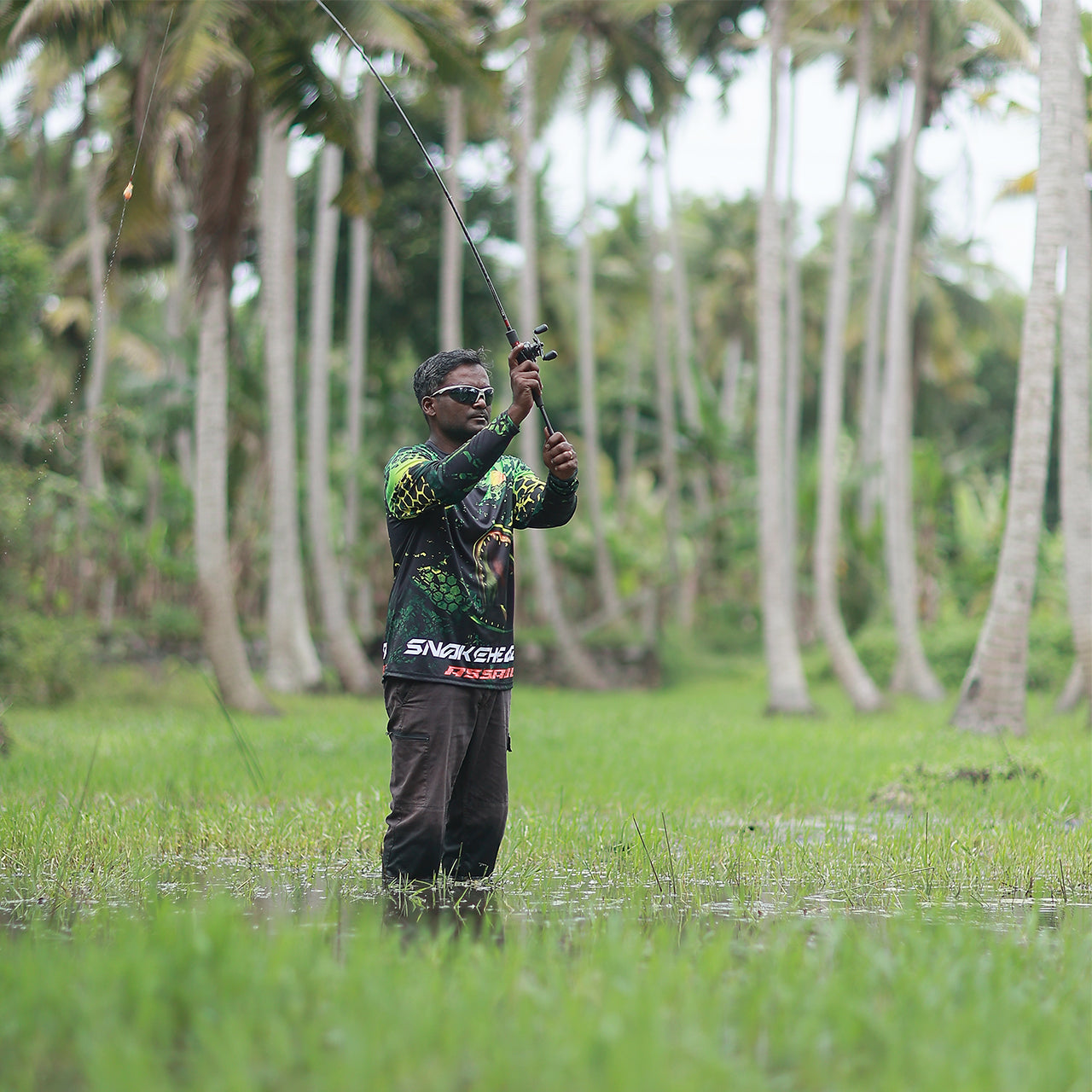 Eyida Snakehead Assault UPF_50_ Hooded Performance Fishing T-Shirt Hanish Standing in Swamp Casting
